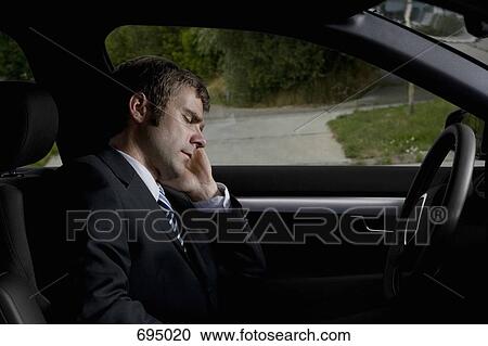 A businessman sleeping in a car View Large Photo Image Stock Image - A businessman sleeping in a car. Fotosearch
