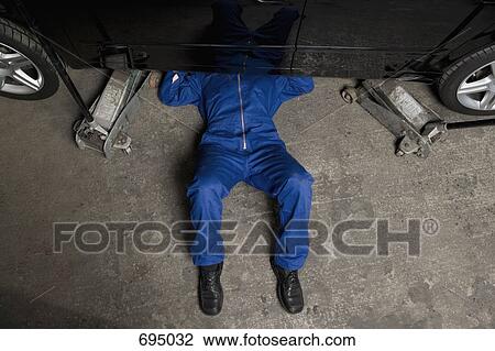 A car mechanic servicing a car View Large Photo Image Stock Image - A car mechanic servicing a car. Fotosearch