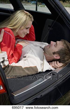 A couple lying together in the back of a car View Large Photo Image Stock Photo - A couple lying together in the back of a car. Fotosearch