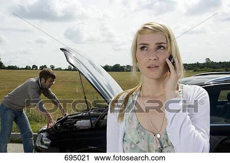 A couple standing at the roadside next to their broken down car View Large Photo Image Stock Image - A couple standing at the roadside next to their broken down car. Fotosearch