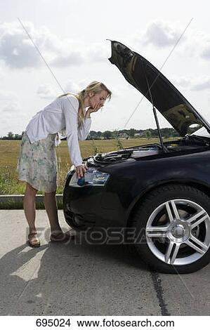 A woman leaning over an open bonnet at the roadside View Large Photo Image Picture - A woman leaning over an open bonnet at the roadside. Fotosearch