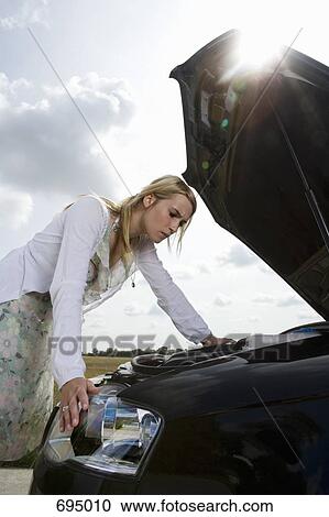 A woman leaning over an open bonnet at the roadside View Large Photo Image Stock Image - A woman leaning over an open bonnet at the roadside. Fotosearch