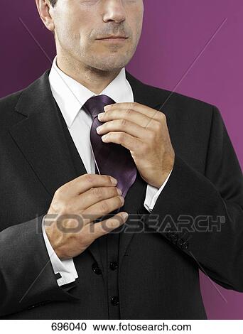 A man adjusting his tie View Large Photo Image Stock Image - A man adjusting his tie. Fotosearch