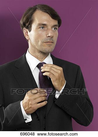 A man adjusting his tie View Large Photo Image Stock Photo - A man adjusting his tie. Fotosearch