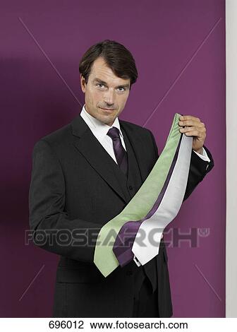 A sales clerk holding ties View Large Photo Image Stock Image - A sales clerk holding ties. Fotosearch
