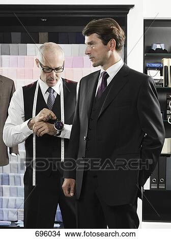 A tailor fitting a man with a suit View Large Photo Image Picture - A tailor fitting a man with a suit. Fotosearch