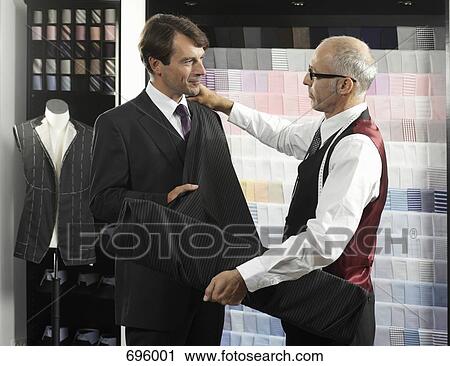 A tailor fitting a man with a suit View Large Photo Image Stock Image - A tailor fitting a man with a suit. Fotosearch