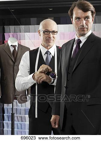 A tailor fitting a man with a suit View Large Photo Image Stock Image - A tailor fitting a man with a suit. Fotosearch