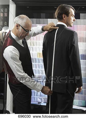 A tailor fitting a man with a suit View Large Photo Image Stock Image - A tailor fitting a man with a suit. Fotosearch