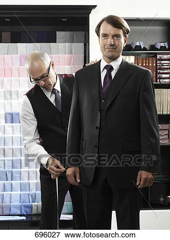 A tailor fitting a man with a suit View Large Photo Image Stock Photo - A tailor fitting a man with a suit. Fotosearch