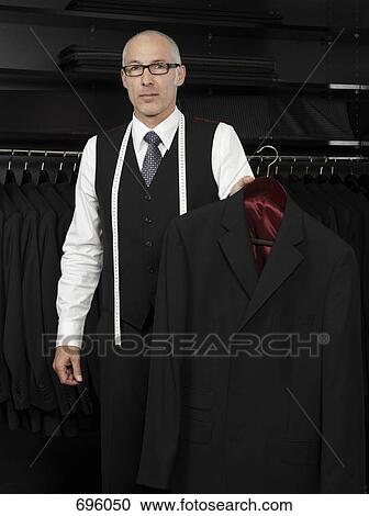 Stock Image - A tailor holding a jacket. Fotosearch