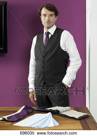 A tailor standing with fabric swatches View Large Photo Image Stock Photography - A tailor standing with fabric swatches. Fotosearch