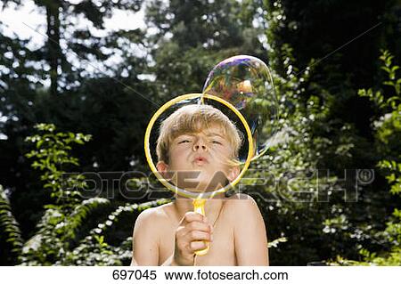 A boy blowing a bubble with a bubble wand View Large Photo Image Stock Photography - A boy blowing a bubble with a bubble wand. Fotosearch