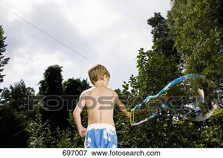A boy making a bubble with a bubble wand View Large Photo Image Stock Photo - A boy making a bubble with a bubble wand. Fotosearch