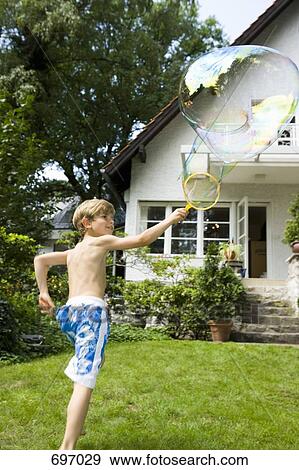 A boy making a bubble with a bubble wand View Large Photo Image Stock Photo - A boy making a bubble with a bubble wand. Fotosearch