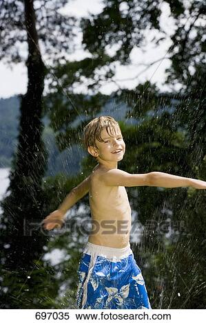 A boy playing in spraying water View Large Photo Image Stock Photography - A boy playing in spraying water. Fotosearch