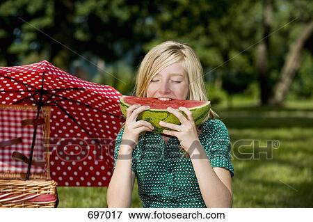 Stock Photo - A girl eating a slice of watermelon. Fotosearch