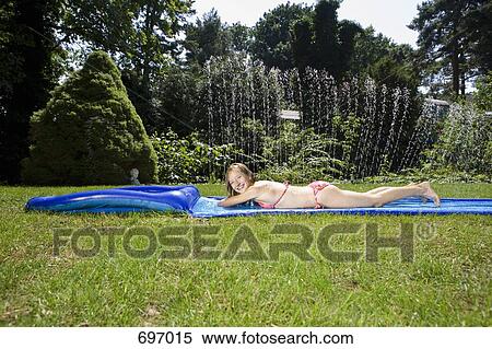 A girl lying on a water slide View Large Photo Image Stock Photography - A girl lying on a water slide. Fotosearch