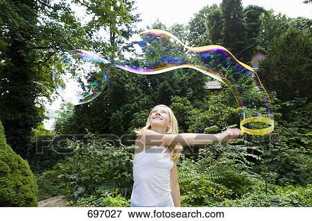 A girl making bubbles with a bubble wand View Large Photo Image Stock Photo - A girl making bubbles with a bubble wand. Fotosearch