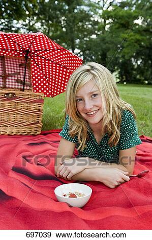 A girl with a bowl of yogurt, granola & strawberries at a picnic View Large Photo Image Stock Photo - A girl with a bowl of yogurt, granola & strawberries at a picnic. Fotosearch