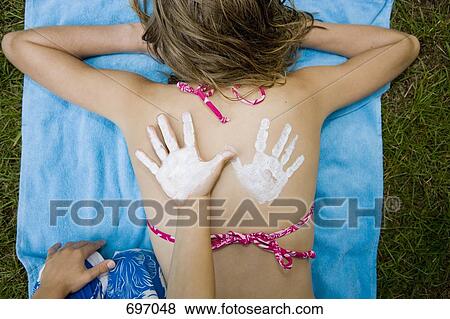 A girl with a suntan lotion handprint on her back and a boy's hand next to it View Large Photo Image Stock Photo - A girl with a suntan lotion handprint on her back and a boy's hand next to it. Fotosearch