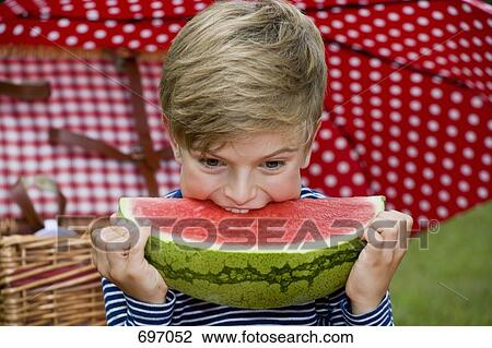 A young boy eating a slice of watermelon View Large Photo Image Stock Image - A young boy eating a slice of watermelon. Fotosearch
