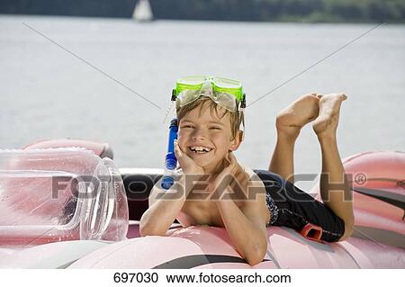A young boy lying on an inflatable raft on a lake View Large Photo Image Stock Image - A young boy lying on an inflatable raft on a lake. Fotosearch