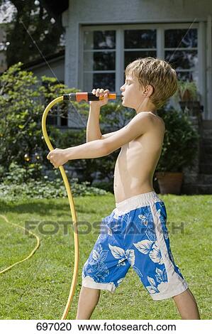 A young boy singing into the end of garden hose View Large Photo Image Stock Image - A young boy singing into the end of garden hose. Fotosearch