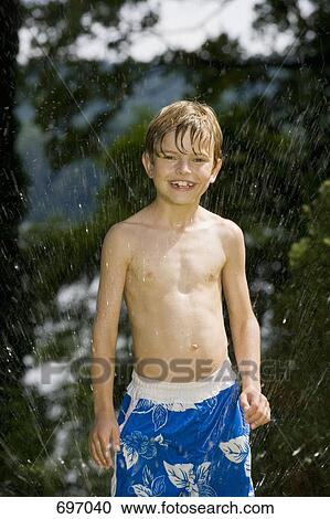 A young boy standing in a sprinkler View Large Photo Image Stock Image - A young boy standing in a sprinkler. Fotosearch