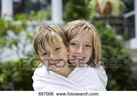Stock Photograph - Brother and sister wrapped in a towel. Fotosearch