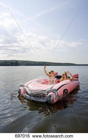 Stock Photograph - Two children in an inflatable raft on a lake. Fotosearch