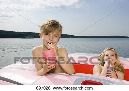 Two children in an inflatable raft on a lake View Large Photo Image Stock Photograph - Two children in an inflatable raft on a lake. Fotosearch