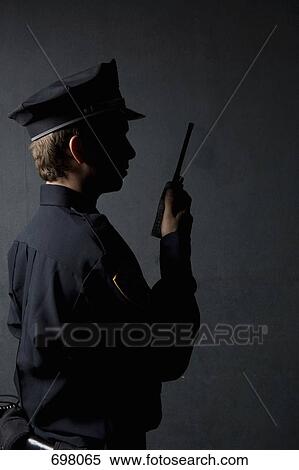 A police officer using a radio View Large Photo Image Stock Photography - A police officer using a radio. Fotosearch