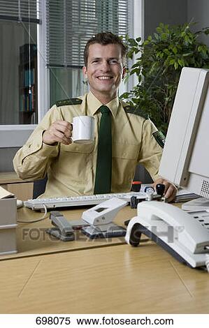Stock Photography - A police officer working in an office. Fotosearch