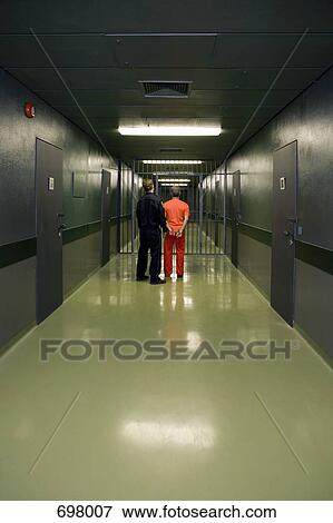 A prison guard leading a prisoner along a corridor View Large Photo Image Stock Photo - A prison guard leading a prisoner along a corridor. Fotosearch