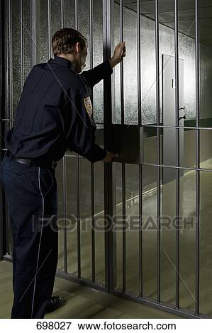 A prison guard locking a prison door View Large Photo Image Stock Photo - A prison guard locking a prison door. Fotosearch