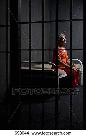 A prisoner sitting on a bed in a prison cell View Large Photo Image Picture - A prisoner sitting on a bed in a prison cell. Fotosearch
