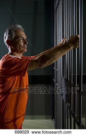 A prisoner standing in his prison cell View Large Photo Image Stock Photo - A prisoner standing in his prison cell. Fotosearch