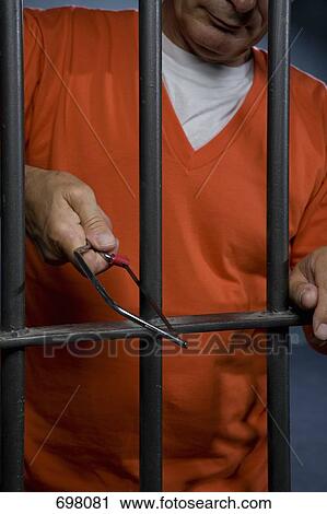 Stock Image - A prisoner trying to escape from his prison cell. Fotosearch
