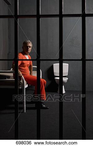 Prisoner sitting on a bed in a prison cell View Large Photo Image Stock Photograph - Prisoner sitting on a bed in a prison cell. Fotosearch