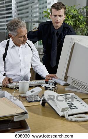 Two police officers working in an office View Large Photo Image Stock Image - Two police officers working in an office. Fotosearch