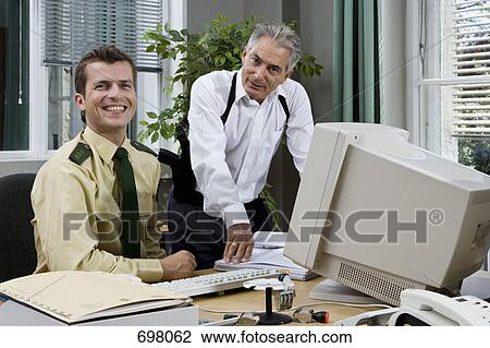 Stock Image - Two police officers working in an office. Fotosearch