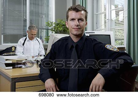 Two police officers working in an office View Large Photo Image Stock Image - Two police officers working in an office. Fotosearch