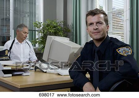 Two police officers working in an office View Large Photo Image Stock Photo - Two police officers working in an office. Fotosearch