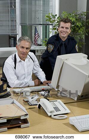 Stock Photo - Two police officers working in an office. Fotosearch