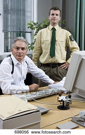 Stock Photograph - Two police officers working in an office. Fotosearch