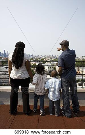 Stock Photo - A family of four standing on a balcony. Fotosearch