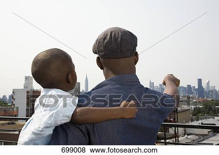 Stock Photo - A father holding his son on a balcony. Fotosearch