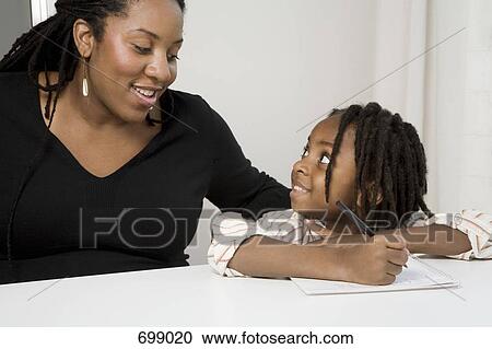 Stock Image - A mother watching her son writing. Fotosearch