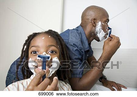 Stock Photograph - A son imitating his father shaving. Fotosearch